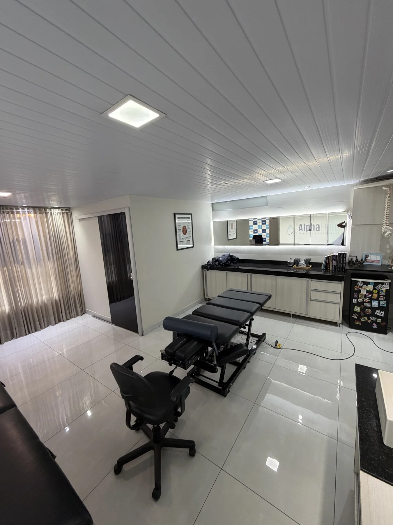 Sala de atendimento da Alphafisio, com maca e espelho